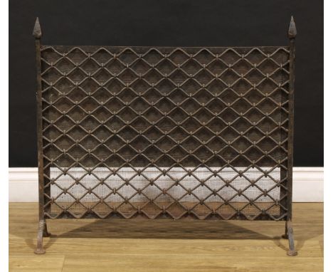 An Arts &amp; Crafts wrought iron and steel fireguard, pyramidal finials, mesh screen, pad feet, 71.5cm high, 79cm wide, c.19