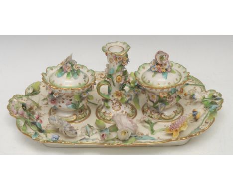 A Coalbrookdale porcelain inkstand, centred by a taper stick and flanked by a pair of urnular inkwells and covers, profusely 