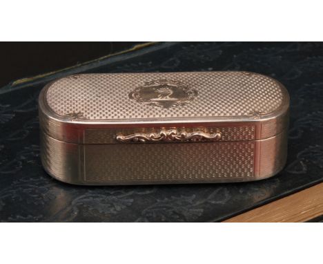A George III style silver rounded rectangular snuff box, engine turned, hinged cover centred by an armorial cartouche, gilt i