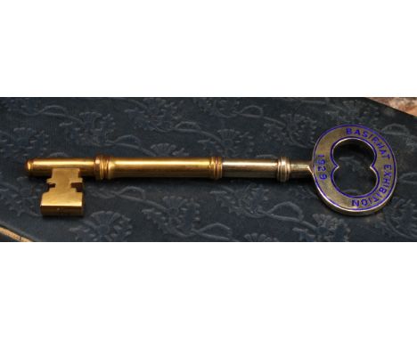 Copoclephily - an Indian silver-gilt coloured metal and enamel presentation key, Basirhat Exhibition 1929, 14cm long, unmarke