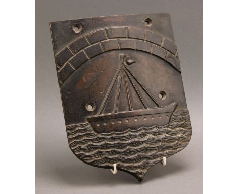 A 19th century bronze business or insurance plaque, of maritime interest, cast with a ship beneath a rusticated arch, 27cm x 