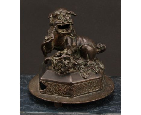 A Chinese bronze, of a foo dog and snake, hexagonal base, 14cm high overall, c. 1900