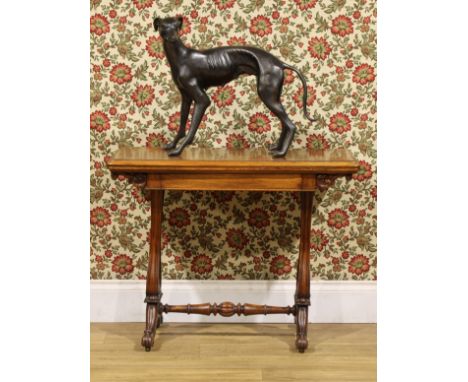 An early Victorian walnut card table, hinged top enclosing a baize lined playing surface, above a frieze drawer, shaped end s