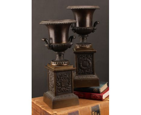 A pair of 19th century brown patinated bronze campana library urns, in the Grand Tour taste, each base cast with trophies emb