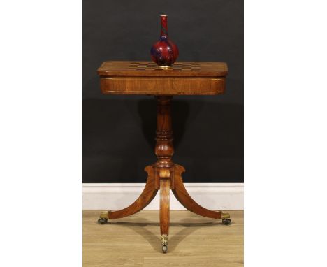 A Regency tulipwood pedestal games table, sliding top inlaid for chess and enclosing a tooled and gilt provision for backgamm