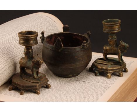 An Indian bronze ghee lamp or candlestick, cast as a cow, 11cm high, 19th century; another, similar; a bronze bowl or incense