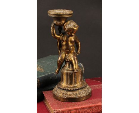 A 19th century gilt bronze figural candlestick, cast as a scantily clad putti, seated on a fluted column, spreading circular 