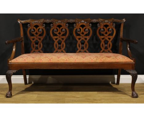 A Chippendale Revival mahogany quadruple-chair-back sofa, folded ribbon splats carved with eagle heads, drop-in seat, cabriol
