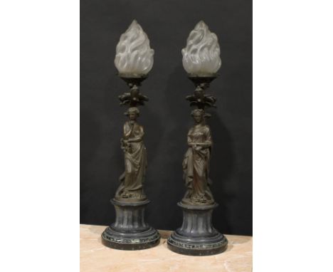 A pair of French brown patinated bronze figural table lamps, cast as personifications of music and literature, glass flame sh