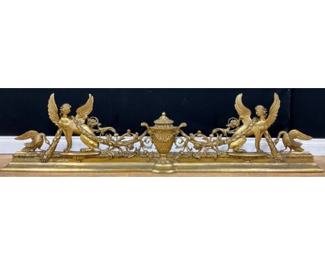 A Neoclassical gilt bronze sculptural fire curb or fender, cast with a Classical urn flanked by Greek sphinxes and birds, dra