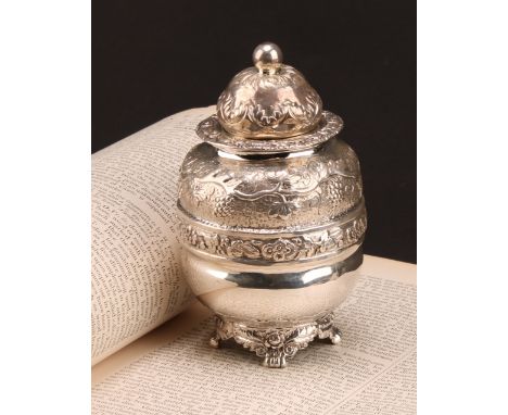 A George IV silver ovoid tea caddy, chased with bands of fruiting vine, domed cover, paw feet, 13cm high, Robert Hennell, Lon