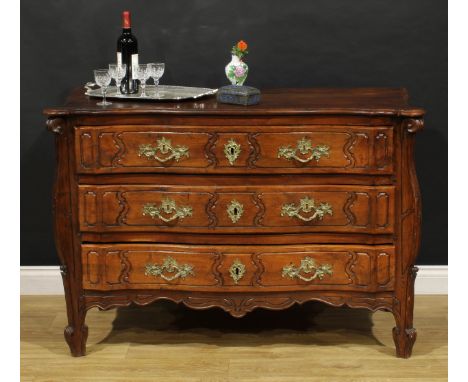 An 18th century French Provincial chestnut serpentine commode, slightly oversailing top above three long drawers, shaped apro