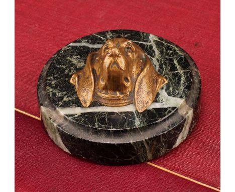 A 19th century circular veined black marble desk weight, the centre mounted with a cast bronze hound mask in relief, 9cm diam
