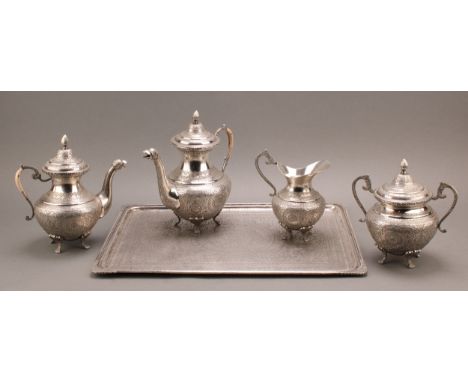 An Iranian silver four piece tea and coffee service and tray, profusely chased in the Persian taste, the tray 46cm wide, fars