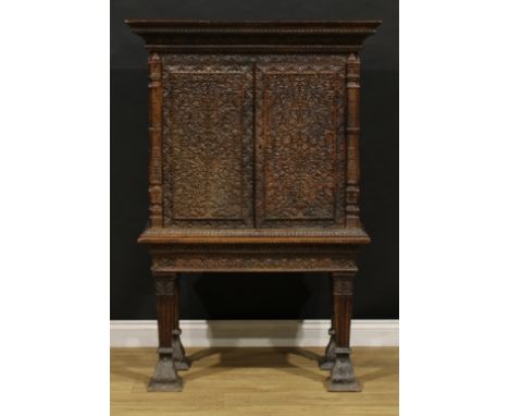An Anglo-Indian or Burmese hardwood pier cabinet, moulded cornice above a pair of doors enclosing a shelf, carved throughout 