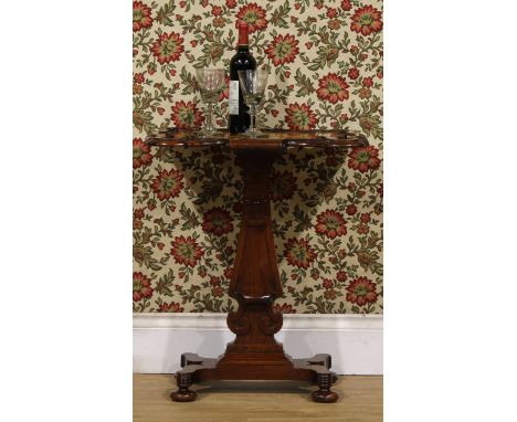 An early Victorian rosewood pedestal games table, shaped hipped rectangular top inlaid for chess and carved with scrolls, bun