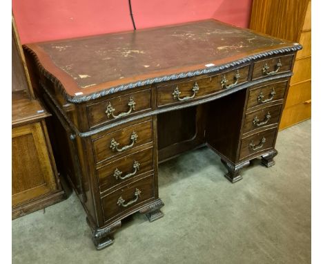 An Edward VII Chippendale style mahogany and leather topped serpentine desk