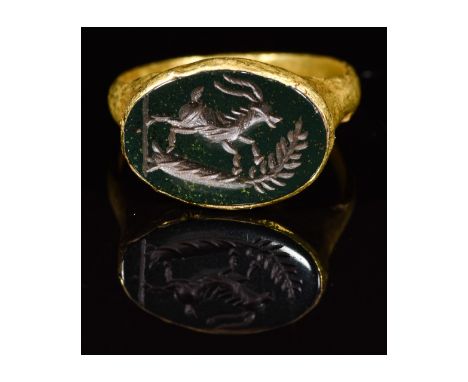 CA. 200 AD. Rare Ancient Roman gold ring; a well-preserved hoop forming an elliptical bezel; beautifully carved green intagli