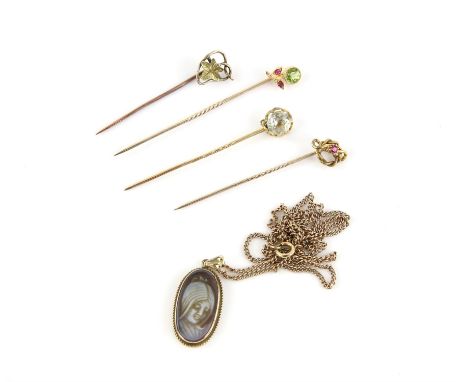 Four stick pins, including a peridot and ruby pin, a ruby pin and an aquamarine pin in 15 ct, another pin in tested 9 ct and 