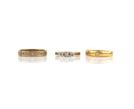 Three rings, including a three stone diamond ring, size J, a single stone diamond ring, size N and a paste eternity ring, siz