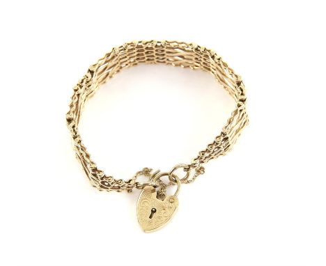 Vintage gold gate bracelet with fancy gold links with sections of brick link between, with an engraved gold heart padlock cla