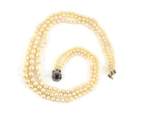 Graduated three strands of pearl necklace, strung with knots, with an antique amethyst and old cut diamond clasp,  estimated 