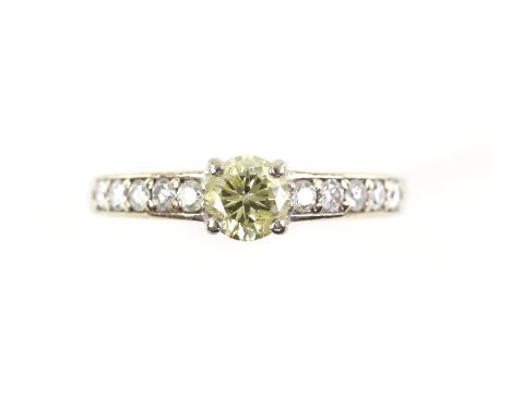 Diamond ring, central fancy yellow diamond weighing an estimated 0.55ct, with five round brilliant cut diamonds set to each s