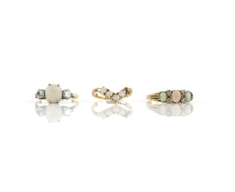 Three rings all set with opals, one with a central round cabochon cut opal and two round brilliant cut diamonds, mounted in 1