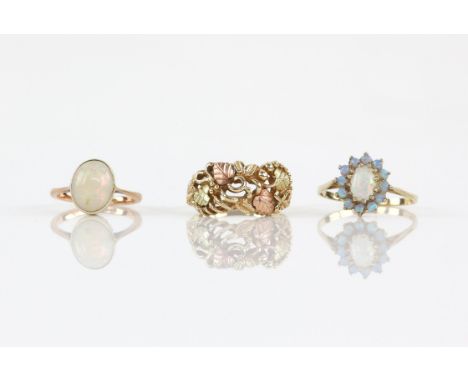Three rings, comprising a single stone oval cabochon cut opal ring, opal 9 x 8 x 4mm, ring size H and a Gilson synthetic opal