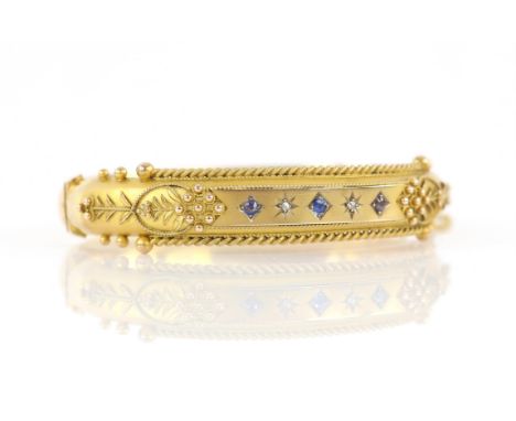 Edwardian diamond and blue paste set bangle, with wirework and floral detailing, concealed clasp and safety chain, in 9 ct ye
