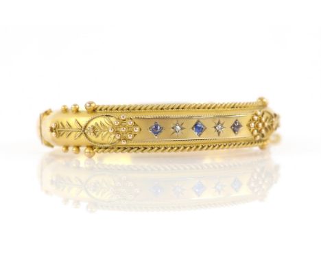 Edwardian diamond and blue paste set bangle, with wirework and floral detailing, concealed clasp and safety chain, in 9 ct ye