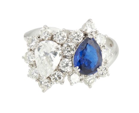 A sapphire and diamond set cluster ringclaw set with a pear shaped diamond and sapphire, in a border of round brilliant cut d