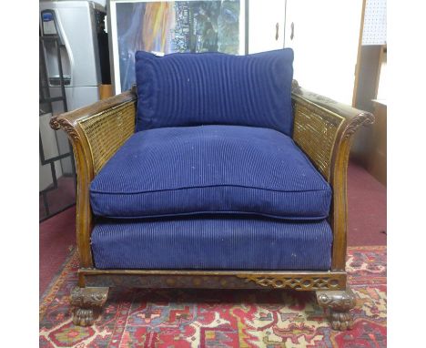 An Edwardian Chippendale style mahogany bergere armchair, with double caning, raised on paw feet 