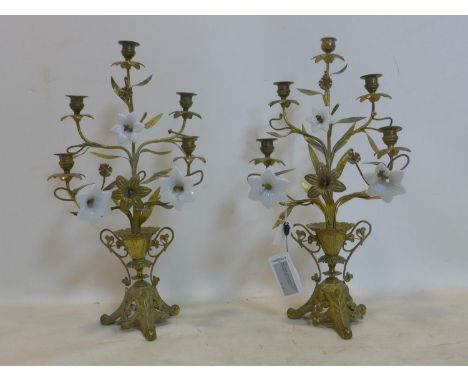 A pair of Continental gilt metal five branch six light candelabras, of urn and flower design with porcelain petals (some miss