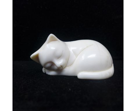 A late 19th century Japanese ivory netsuke modelled as a sleeping cat, signed to base, approx. H.3 W.5.5 D.3.2cm 