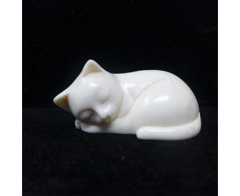 A late 19th century Japanese ivory netsuke modelled as a sleeping cat, signed to base, approx. H.3 W.5.5 D.3.2cm 