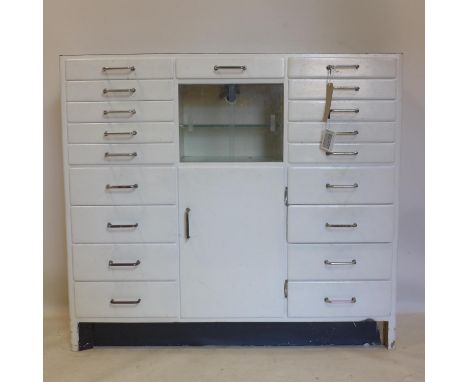 A vintage medicine/dentists cabinet with 2 glass sliding doors above cupboard door, flanked by 18 drawers, H.97 W.109 D.34cm 