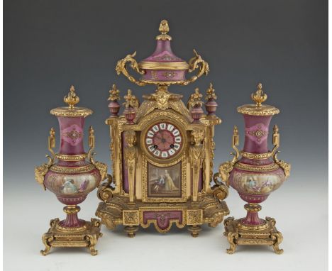 A FRENCH GILT METAL AND PORCELAIN MOUNTED THREE PIECE GARNITURE, c.1880, comprising a mantle clock and twin urns. The clock s
