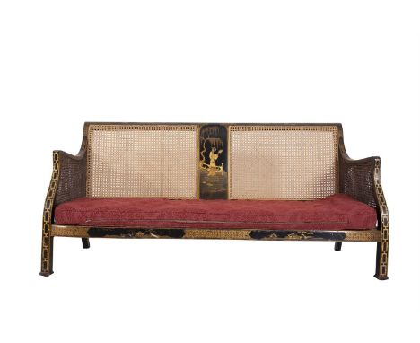 AN EARLY 20TH CENTURY LACQUERED FRAME BERGERE SOFA, the black ground decorated with chinoiserie landscapes in gilt, with cane