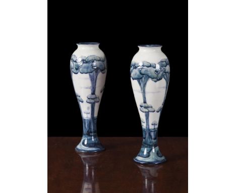 A WILLIAM MOORCROFT BURSLEM CHINA PAIR OF CIRCULAR BALUSTER TAPERING SLENDER VASES, decorated with continuous row of tall tre