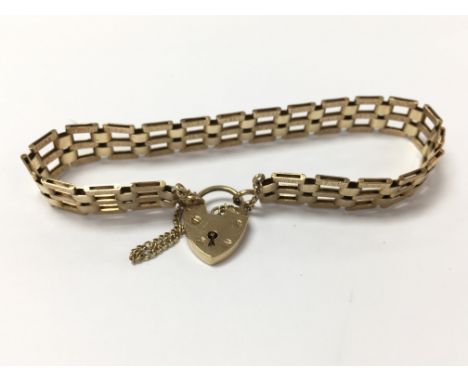 A 9ct gold gate bracelet with a heart padlock. Weighing approximately 11.7g.