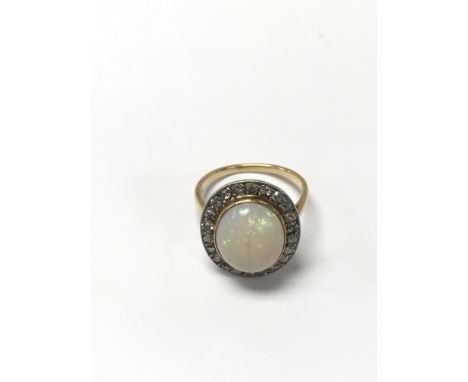 An unmarked gold ring set with a large Opal and surrounded by diamonds. The approximate ring size is L.