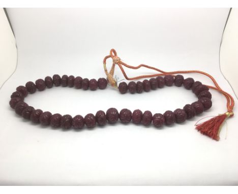 A large necklace set with earth mined carved ruby with adjustable slip knot and patterned cord, rubies approx 798ct.