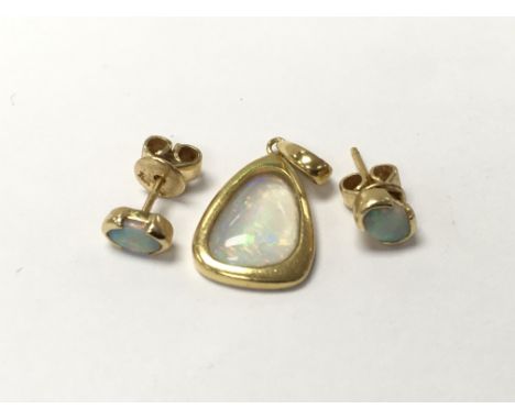 An 18ct gold opal pendant and pair of opal stud earrings.