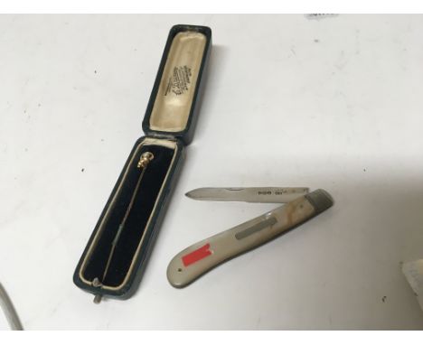 A 15ct gold top stick pin and a mother of Pearl and silver folding knife (2)