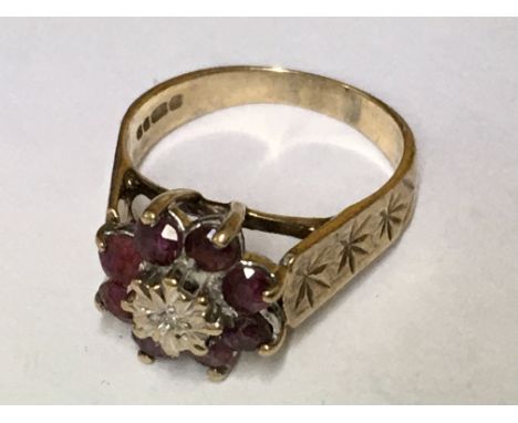 A ruby and diamond reverse cluster ring in the form of a flower, with diamond cut shoulder. Ring size L