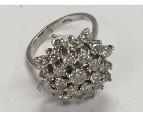 An 18ct white gold cluster ring of star shape. Ring size M