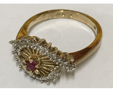 A ruby and diamond cluster ring in gold. Ring size M