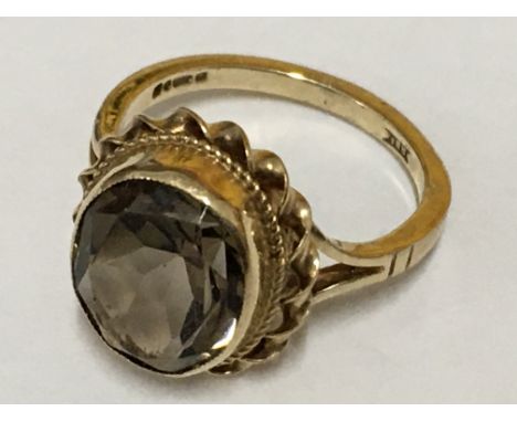 An oval Smokey quartz fancy ring set in yellow gold. Ring size K