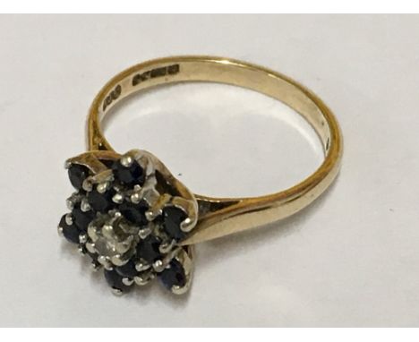 A gold cluster ring inset with sapphire and diamond in the form of a flower. Ring size M